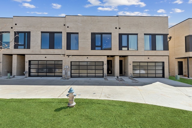 townhome / multi-family property featuring driveway, a garage, and a front yard