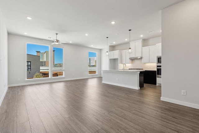 unfurnished living room featuring ceiling fan, dark wood finished floors, and recessed lighting