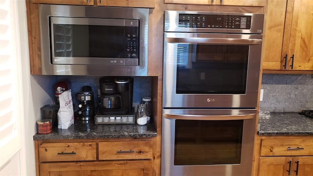 kitchen with appliances with stainless steel finishes, decorative backsplash, and dark stone countertops