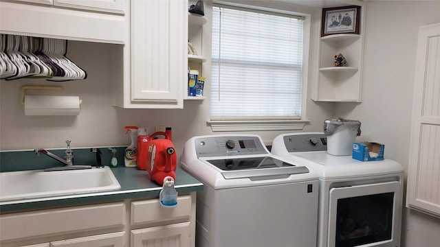 laundry area featuring separate washer and dryer, a wealth of natural light, sink, and cabinets