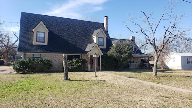 cape cod home featuring a front lawn