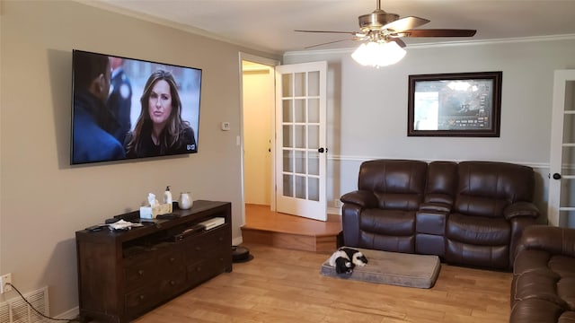 living room with ornamental molding, light hardwood / wood-style floors, and ceiling fan