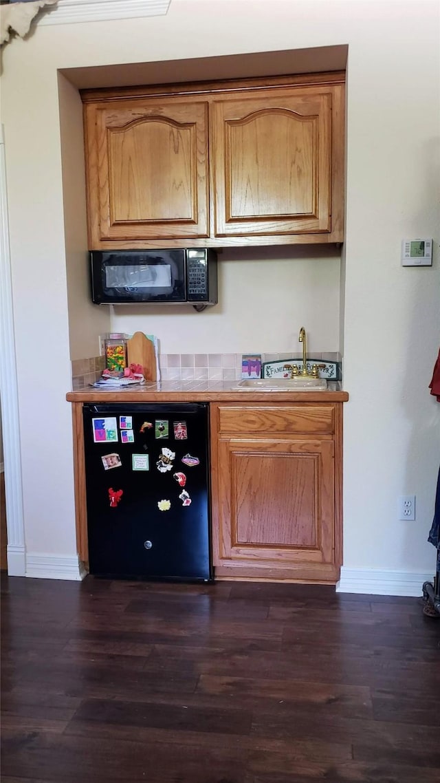 bar with dark wood-type flooring and dishwasher