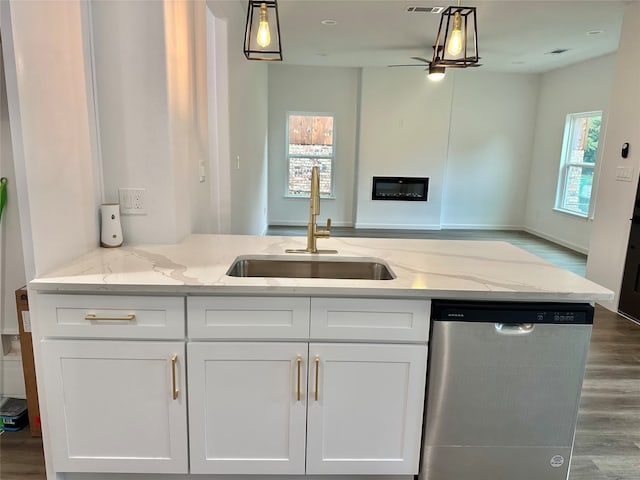 kitchen featuring hardwood / wood-style floors, white cabinetry, sink, light stone countertops, and stainless steel dishwasher