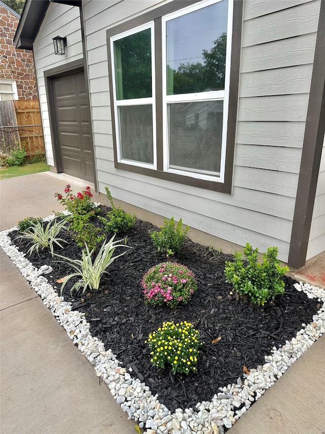 exterior space featuring fence and a garage