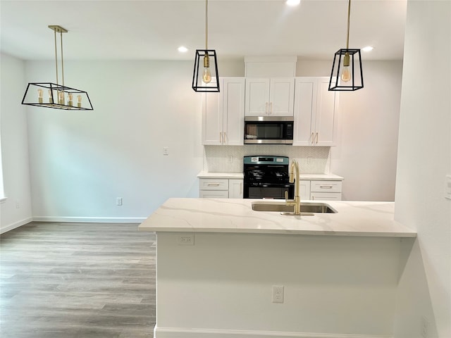 kitchen featuring black stove, backsplash, kitchen peninsula, sink, and white cabinets