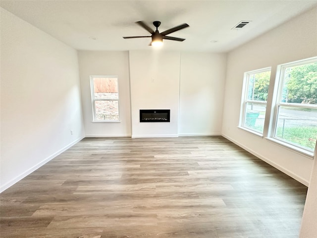 unfurnished living room with ceiling fan and hardwood / wood-style floors