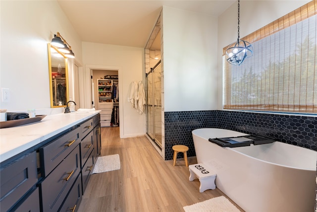 bathroom featuring vanity, wood-type flooring, and shower with separate bathtub