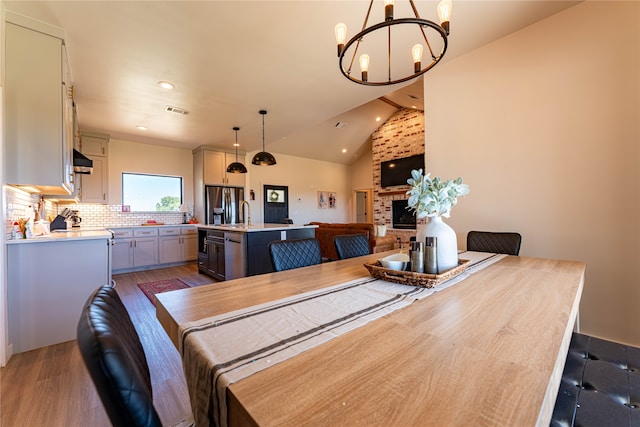 dining space with vaulted ceiling, dark hardwood / wood-style flooring, and a chandelier