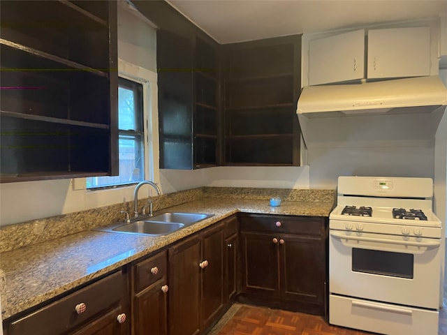 kitchen with white range with gas cooktop, dark parquet floors, light stone counters, and sink