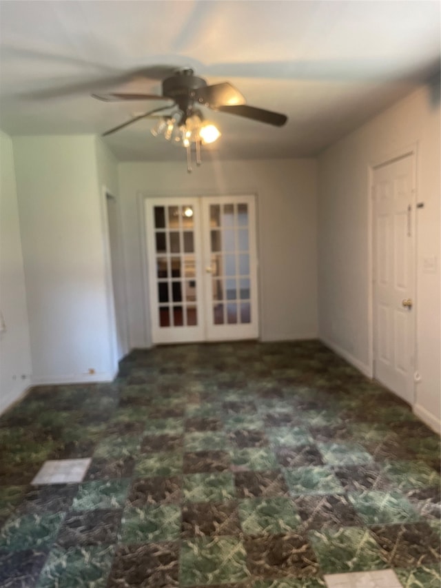 carpeted spare room featuring ceiling fan and french doors