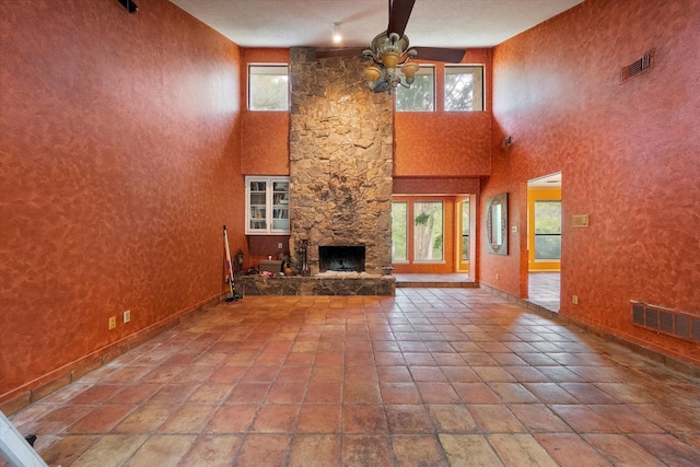 unfurnished living room with a fireplace, a healthy amount of sunlight, and ceiling fan