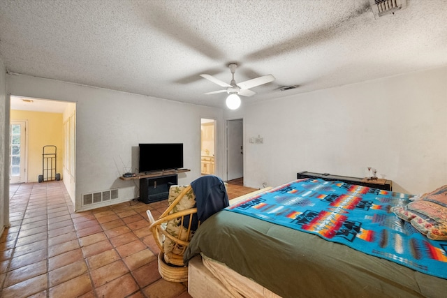 tiled bedroom featuring a textured ceiling and ceiling fan