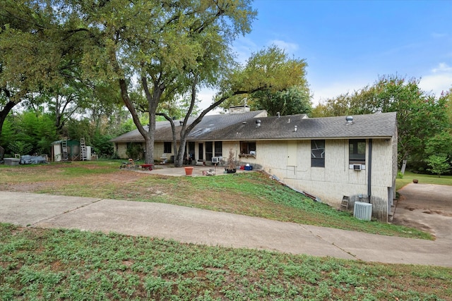 ranch-style house with central AC unit, a patio area, and a front lawn