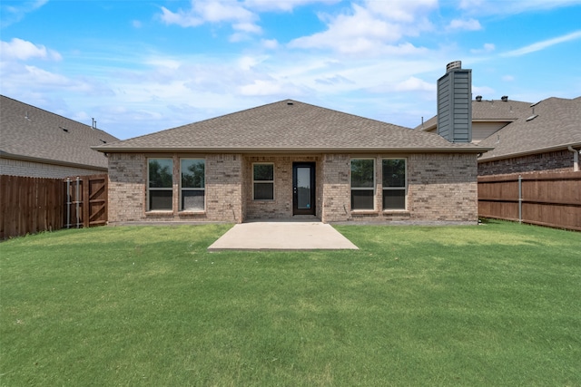 back of property with a yard and a patio area