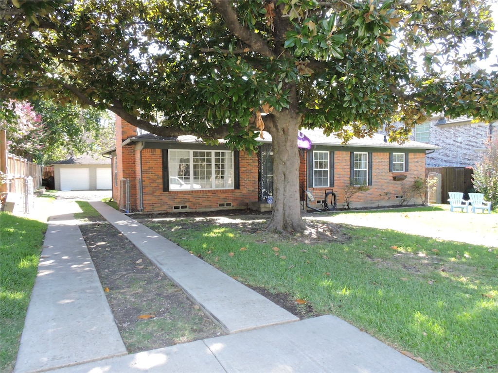 view of front of home with a garage, a front lawn, and an outbuilding