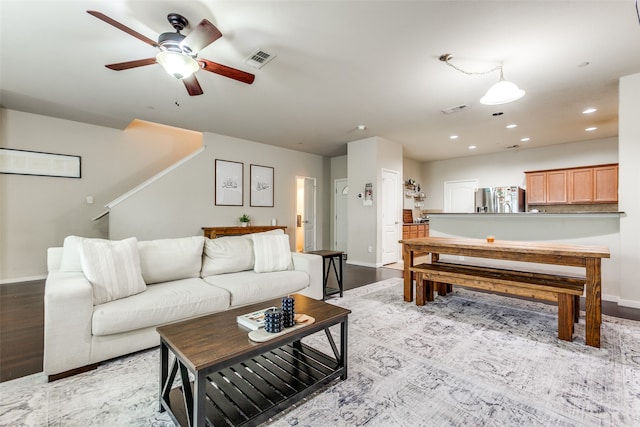 living room featuring ceiling fan and light hardwood / wood-style floors