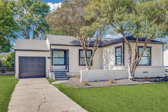 ranch-style house with a garage and a front lawn