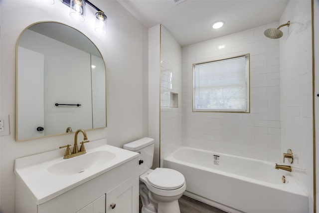 full bathroom with hardwood / wood-style floors, toilet, tiled shower / bath combo, and vanity