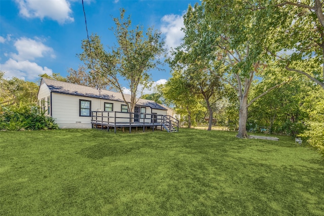 back of property with a wooden deck and a lawn