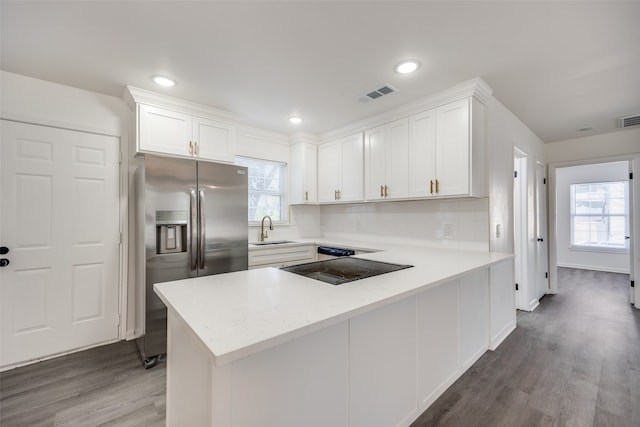 kitchen with white cabinets, hardwood / wood-style flooring, stainless steel fridge with ice dispenser, and sink