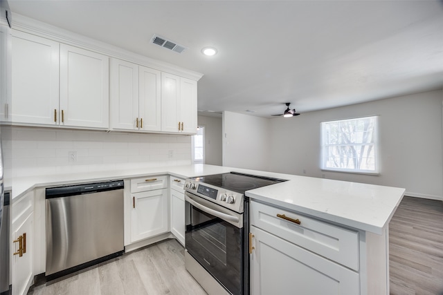 kitchen with white cabinets, light wood-type flooring, appliances with stainless steel finishes, kitchen peninsula, and ceiling fan