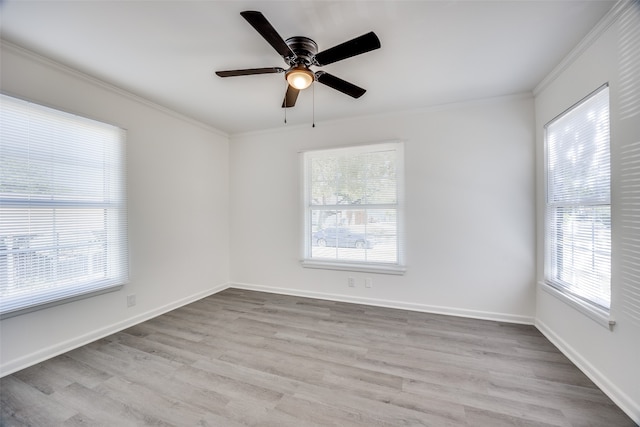 spare room featuring light hardwood / wood-style flooring, ceiling fan, ornamental molding, and a healthy amount of sunlight