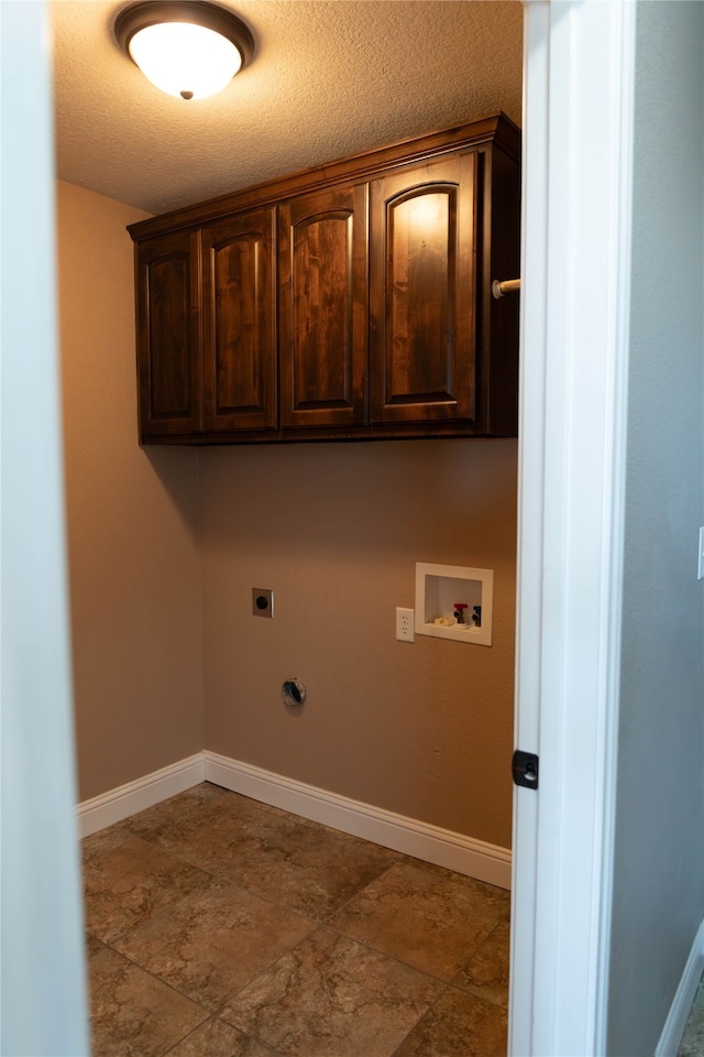 washroom featuring hookup for an electric dryer, a textured ceiling, hookup for a gas dryer, cabinets, and hookup for a washing machine