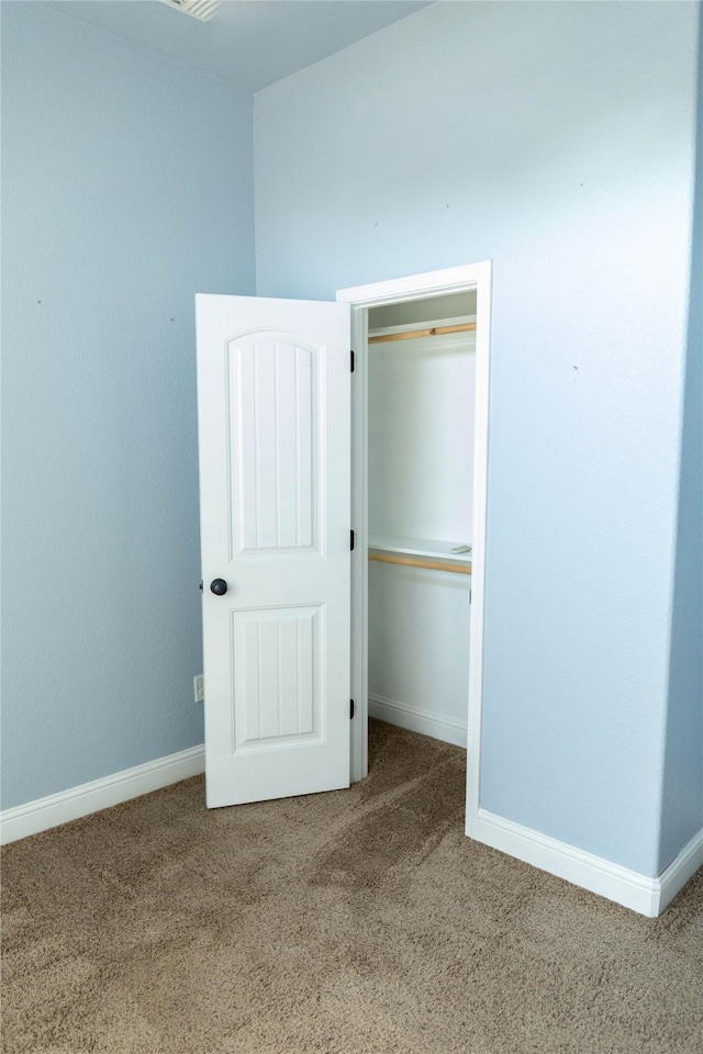 unfurnished bedroom featuring carpet floors and a closet