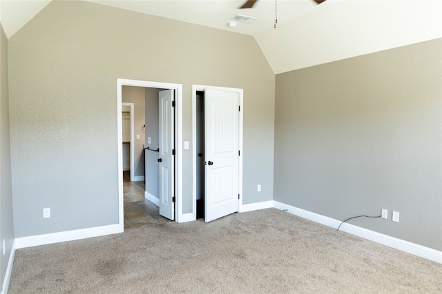 unfurnished bedroom featuring light carpet, lofted ceiling, and ceiling fan