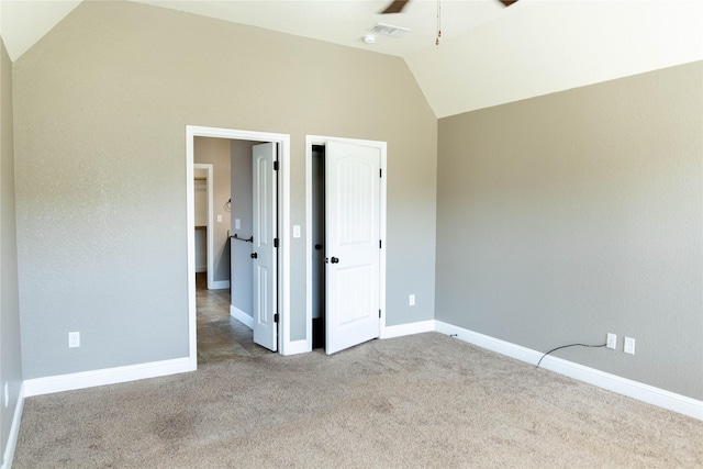 unfurnished bedroom with lofted ceiling, visible vents, a ceiling fan, baseboards, and carpet flooring