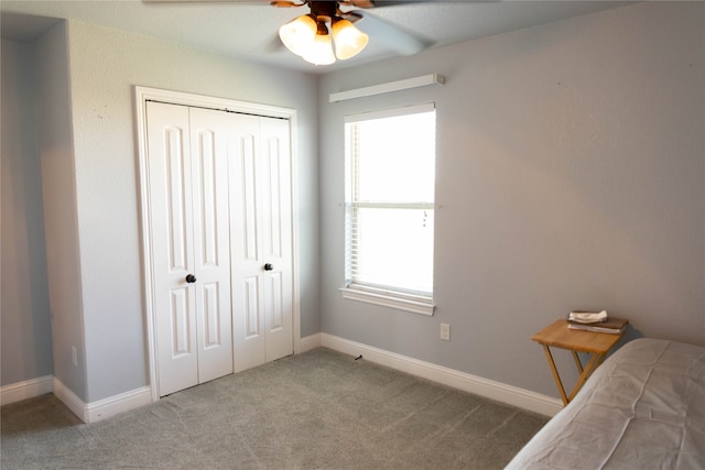 carpeted bedroom featuring ceiling fan and a closet