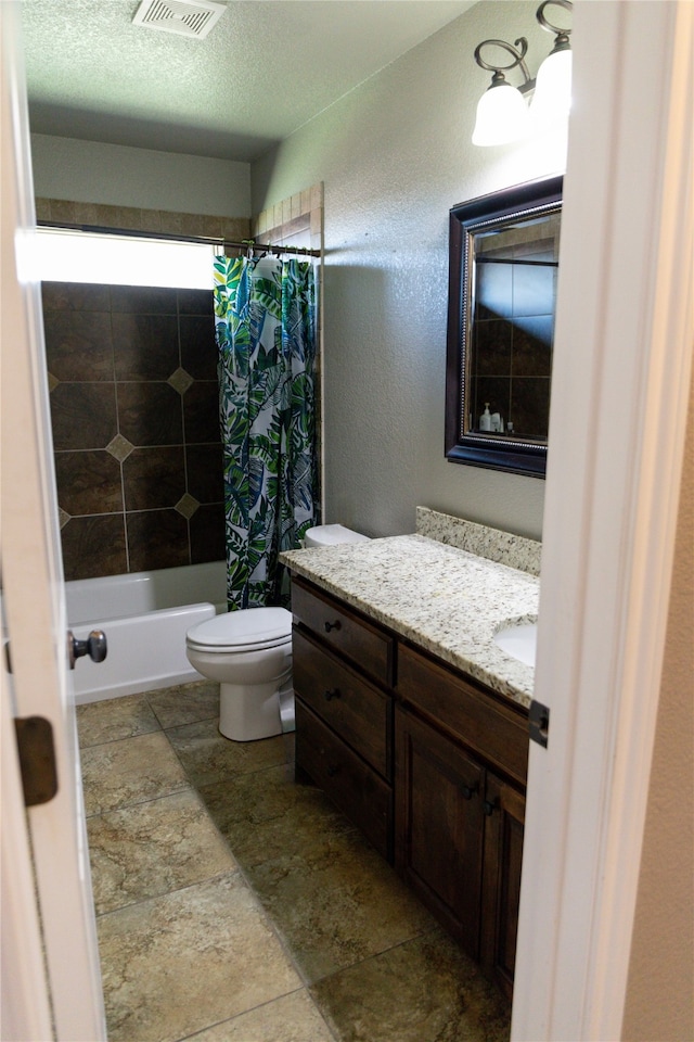 full bathroom featuring vanity, toilet, a textured ceiling, and shower / bath combo