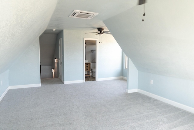additional living space featuring carpet, visible vents, lofted ceiling, and baseboards