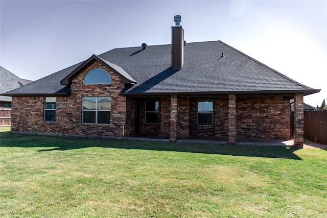 back of house featuring a lawn and a patio area