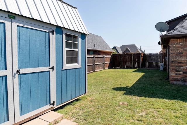 view of yard featuring a storage shed, an outbuilding, and a fenced backyard