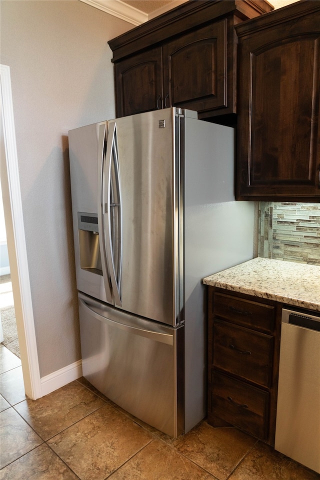 kitchen with light stone countertops, dark brown cabinetry, stainless steel appliances, tasteful backsplash, and light tile patterned floors