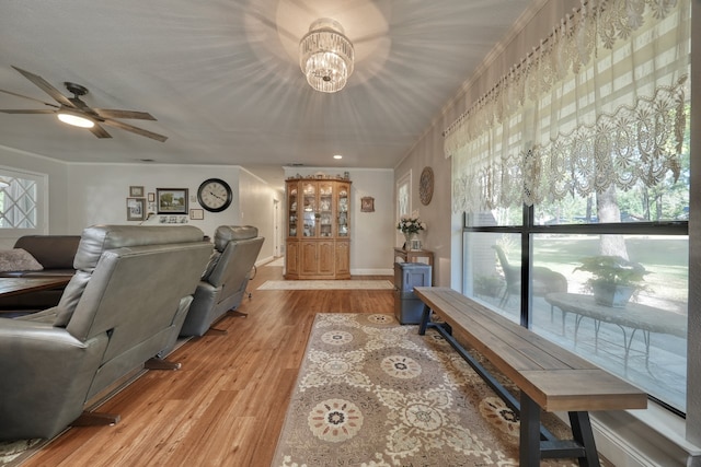 living room featuring ceiling fan with notable chandelier and light hardwood / wood-style floors