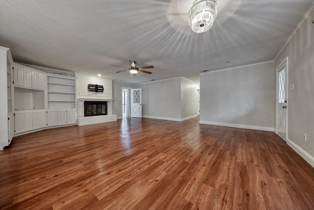 living room featuring a textured ceiling, a large fireplace, ceiling fan, and light wood-type flooring