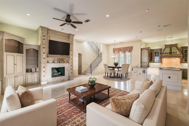 living room featuring light tile patterned floors, ornamental molding, and ceiling fan