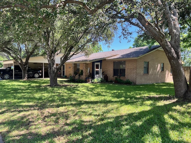 single story home featuring a carport, brick siding, and a front lawn