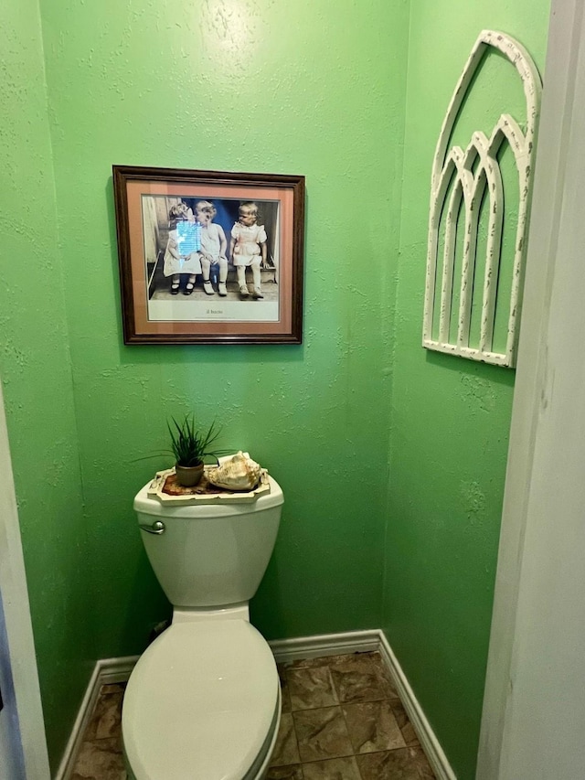 bathroom featuring toilet and baseboards