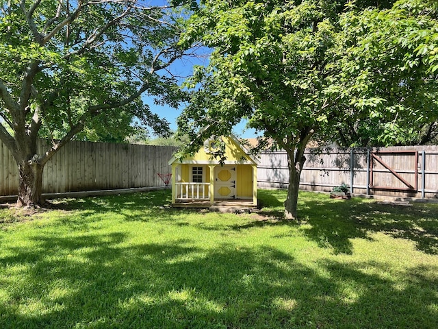 view of yard featuring an outbuilding, a storage unit, and a fenced backyard