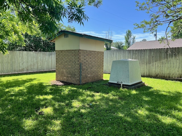 view of yard featuring a storage shed, an outdoor structure, and a fenced backyard