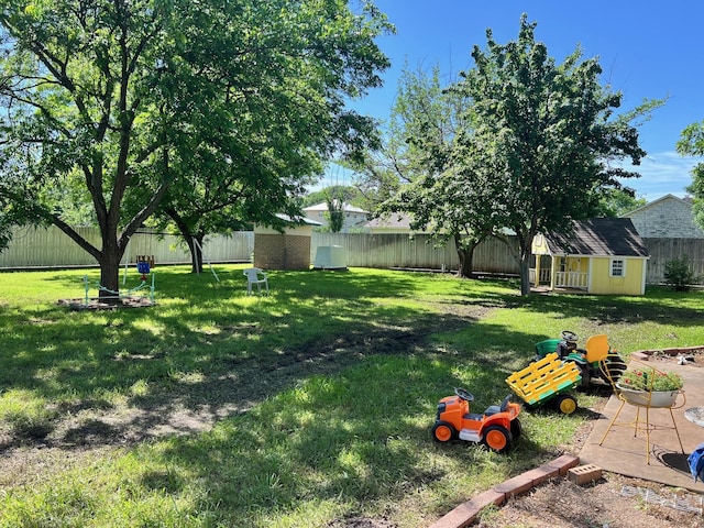 view of yard with an outbuilding, a storage unit, and a fenced backyard