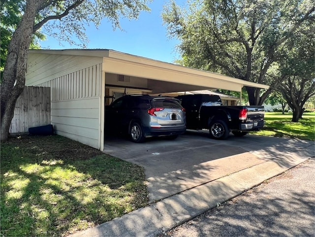 view of car parking featuring fence and driveway