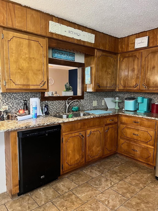 kitchen featuring dishwasher, brown cabinets, backsplash, and a sink