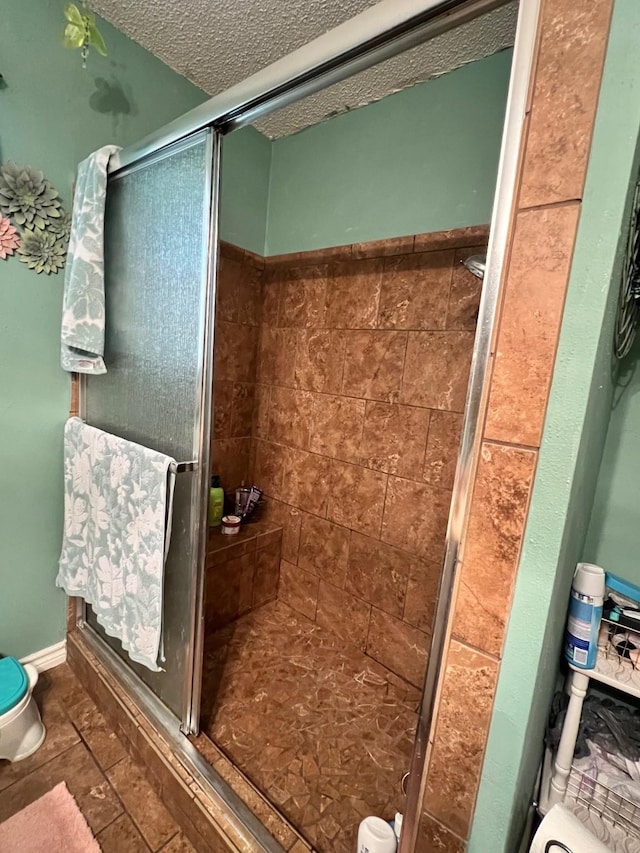 bathroom featuring a shower stall and a textured ceiling