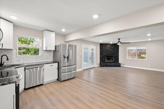 kitchen featuring appliances with stainless steel finishes, white cabinetry, and a healthy amount of sunlight