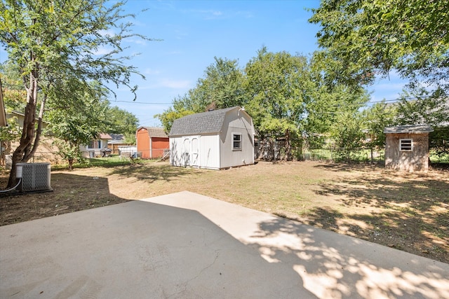 view of yard featuring a storage shed and central air condition unit